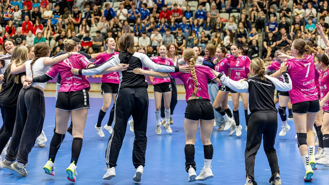Équipe féminine en maillots roses célébrant sa victoire à la Prague Handball Cup